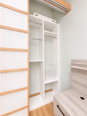 A walk-in closet with open shelves, a hanging rod, and a storage bin. - Elevated Downtown Extended Stay in a Nearly 2,000-Square-Foot Loft (St. Louis)