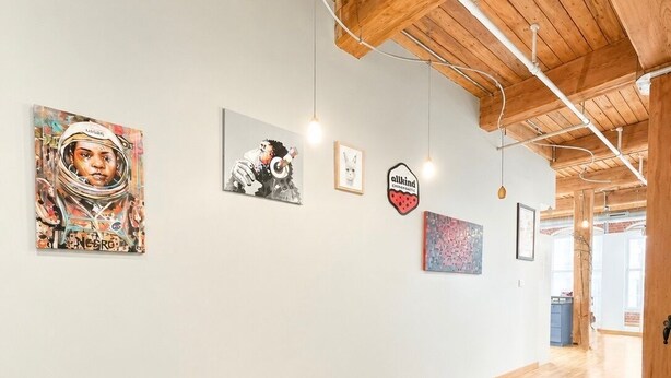 A gallery with wooden floors and a high ceiling with exposed beams.