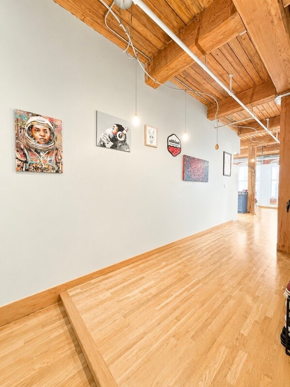 A gallery with wooden floors and a high ceiling with exposed beams.