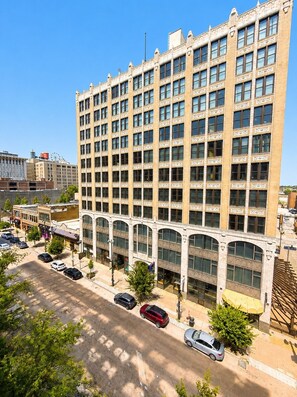 A multi-story building with a symmetrical facade, large windows, and a central entrance with an arched design.