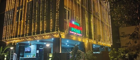 Entrada de un hotel con un cartel que dice 'Hotel Mabhavi Prime' y una zona de recepción.