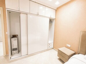 A bedroom with a bed, a bedside table, a wardrobe, and a mirror. - The Harbor Nest- 10min car ride to the beach
Nearby Souk/market and restaurants. (Agadir)