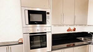 Eine Küche mit integriertem Mikrowellenherd, Backofen und Spüle.