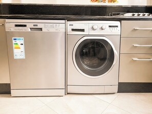 Una lavadora y secadora compactas con panel de control digital, lavadora de carga frontal y exterior de acero inoxidable.
