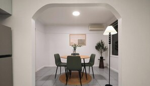 A dining area with a round table, four chairs, a potted plant, and a floor lamp. - KozyGuru | Broadmeadows | Cozy Home Near Airport (Broadmeadows)