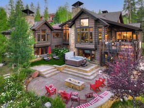 A log cabin with a stone chimney, a hot tub, and outdoor seating. - NEW Double Eagle Lodge on Golf Course, Hot Tub, Gym, VIEWS Outdoor Paradise (Breckenridge)
