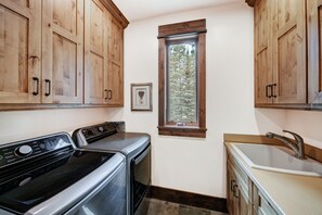 A compact kitchen with wooden cabinets, a built-in oven, a stovetop, and a sink. - NEW Double Eagle Lodge on Golf Course, Hot Tub, Gym, VIEWS Outdoor Paradise (Breckenridge)