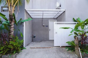 A narrow entrance with a white door, a small air conditioning unit, and a concrete floor. - Private 2BR Villa & Pool - Rice Field Views - Canggu (Dalung)