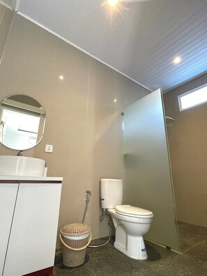 Un baño moderno con inodoro, lavabo y espejo.