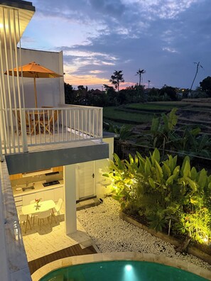 Una casa moderna con balcón, piscina y jardín.