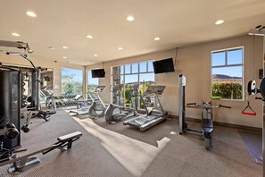A gym with treadmills, elliptical machines, and weightlifting equipment.