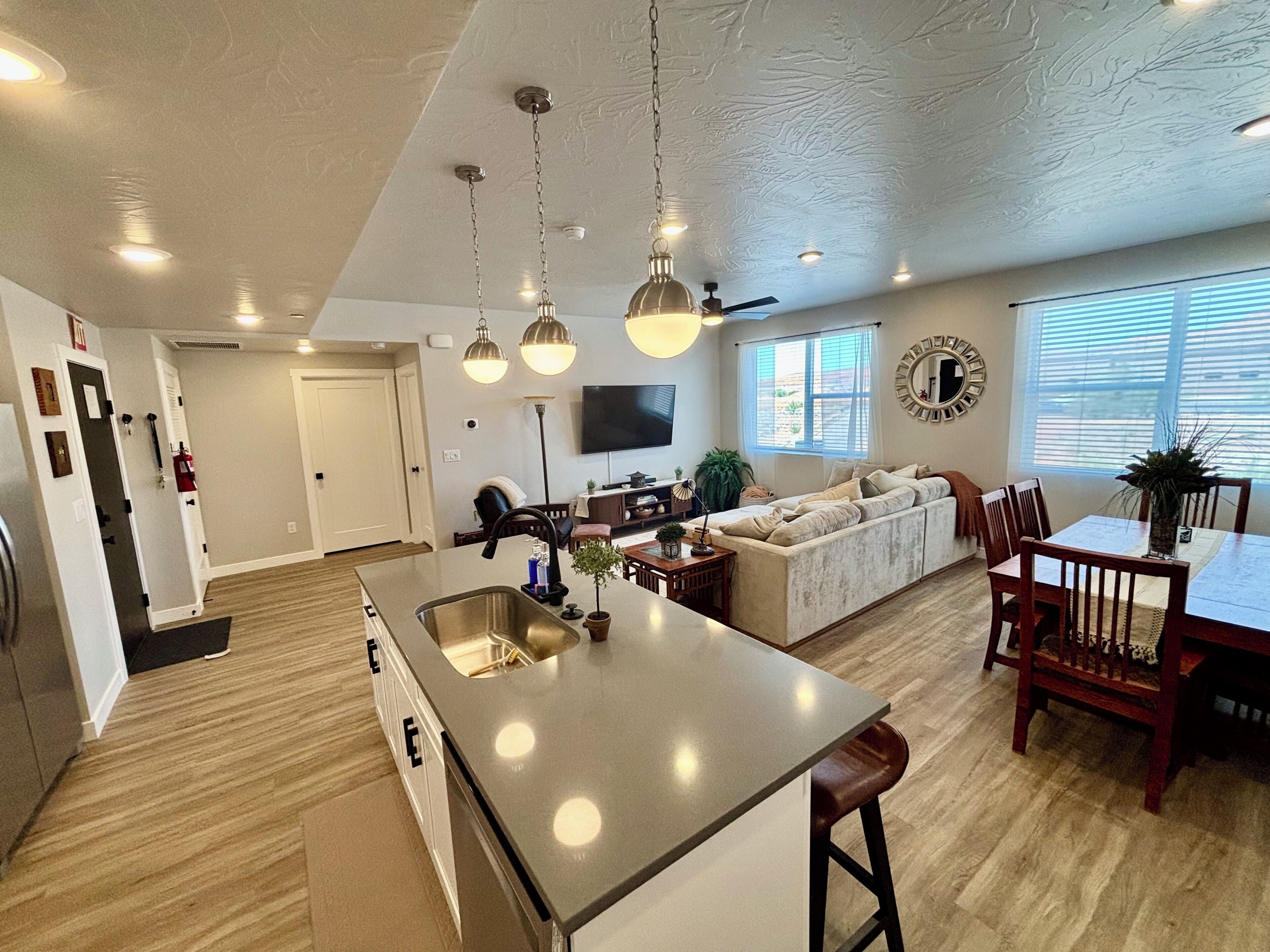 A spacious living area with a large island, a sofa, and a dining table.