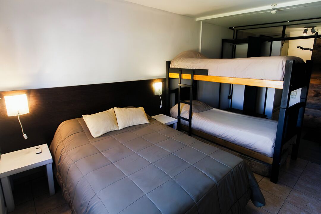 Dormitorio con literas, una cama individual y una mesita de noche.