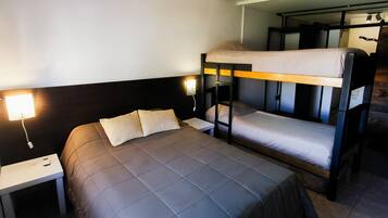 Dormitorio con literas, una cama individual y una mesita de noche.