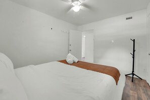 Ein Hotelzimmer mit einem Bett, einem Standheizkörper und einer Tür zu einem weiteren Raum.