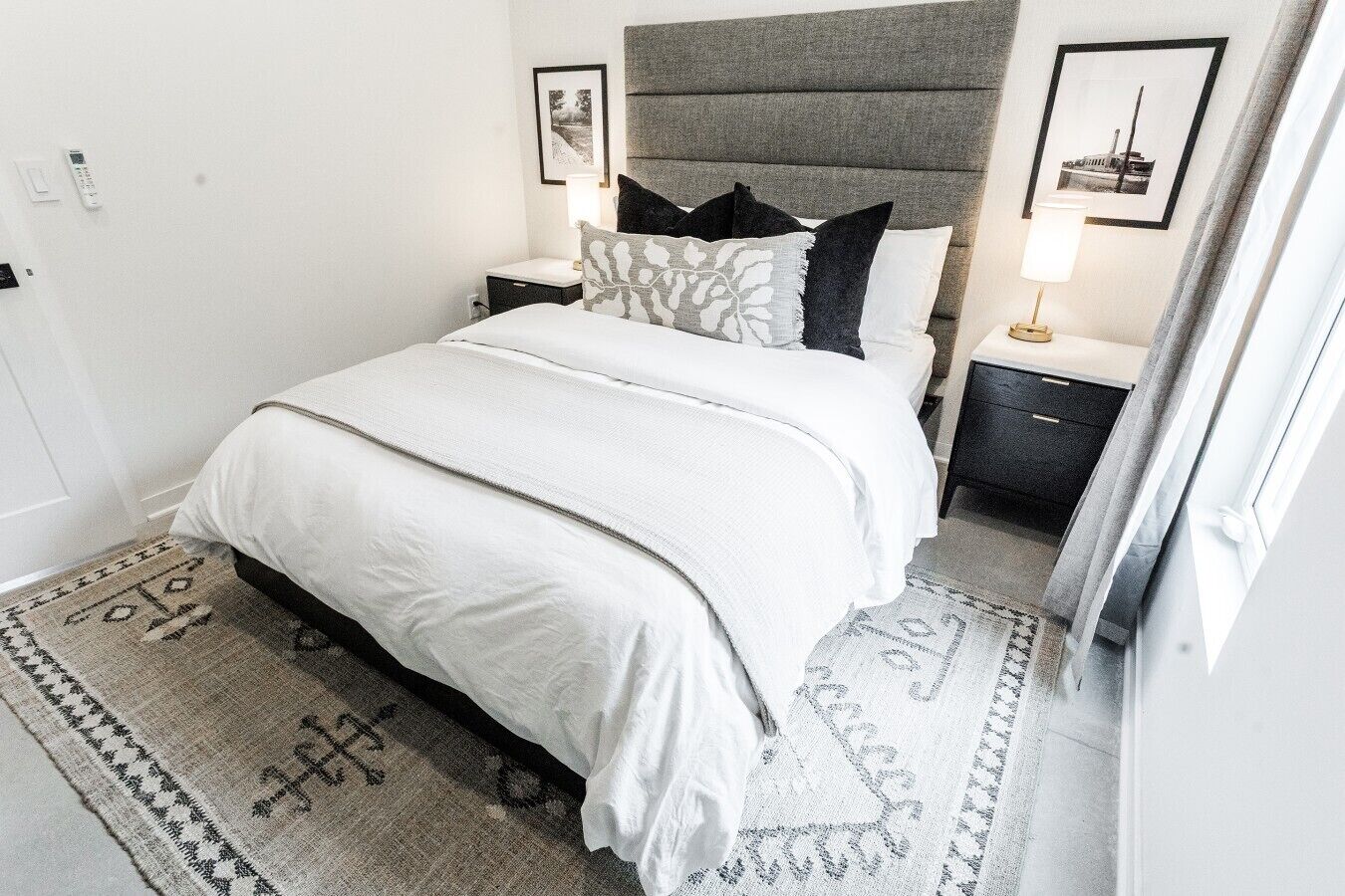Une chambre à coucher bien rangée, avec un lit, des tables de chevet et une tête de lit.