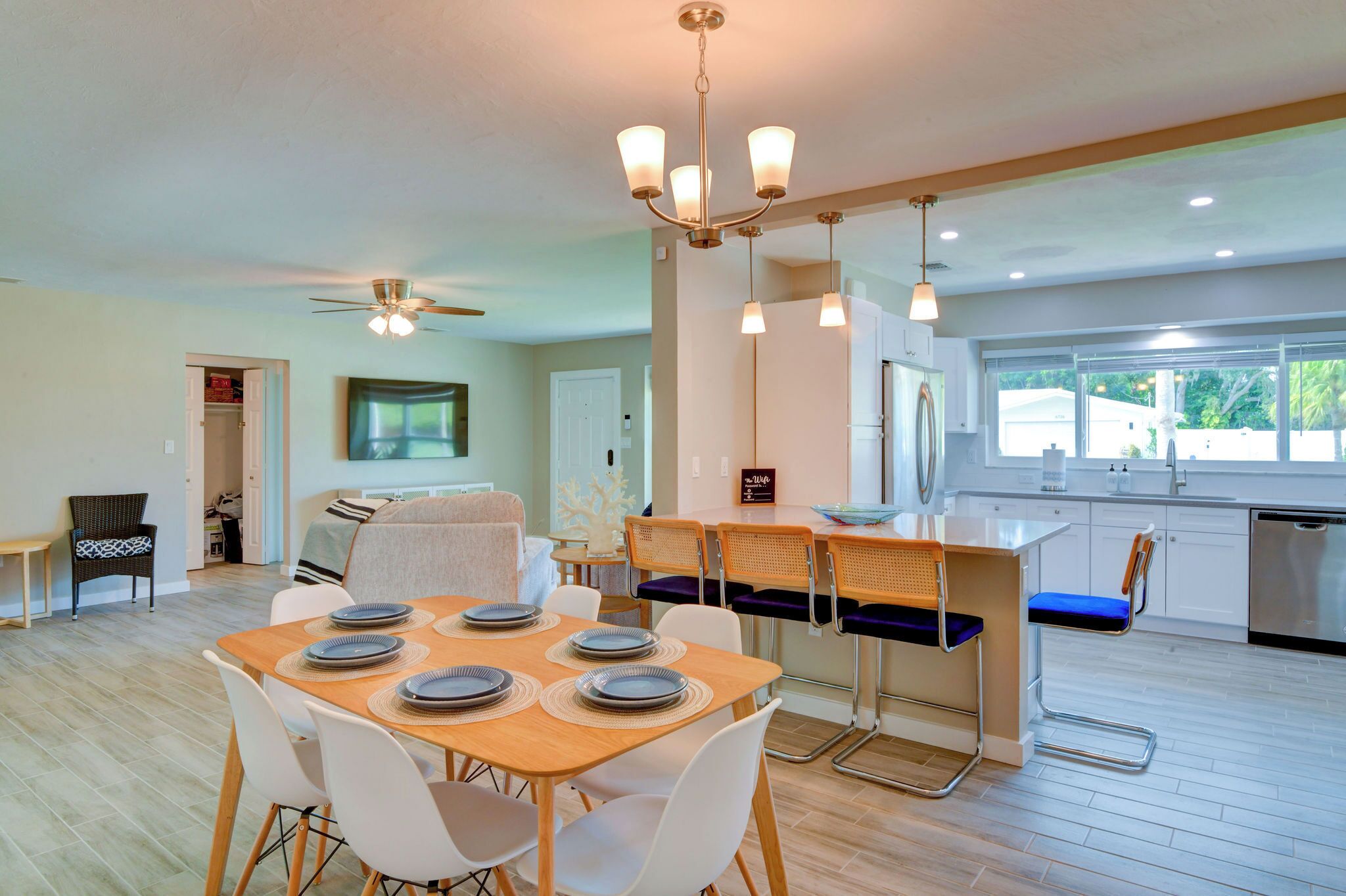 Une cuisine moderne avec un coin repas, un ventilateur de plafond et une grande fenêtre.