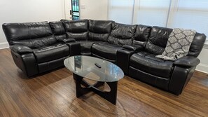 Ein Ecksofa mit einem Glastisch in einem Wohnzimmer.