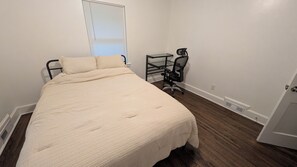 A bedroom with a bed, a desk, and a chair. - Airport-Adjacent 3 Bedroom 2 Bath Cottage (Charlotte)