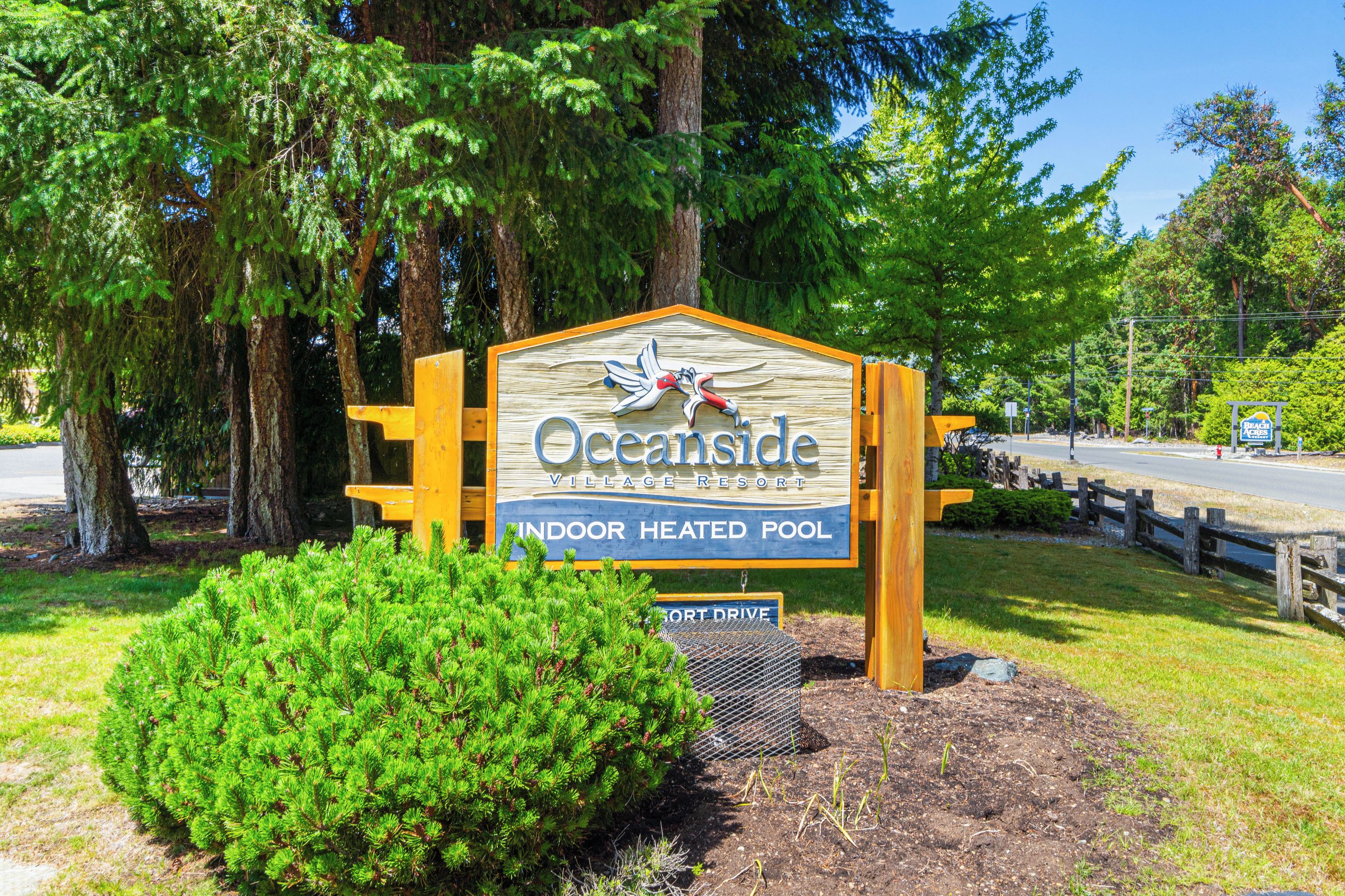 A sign for Oceanside Village Resort with an indoor heated pool.