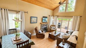 A spacious living room with a fireplace, comfortable seating, and a view of the outdoors.