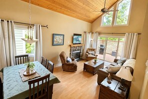 A spacious living room with a fireplace, comfortable seating, and a view of the outdoors.