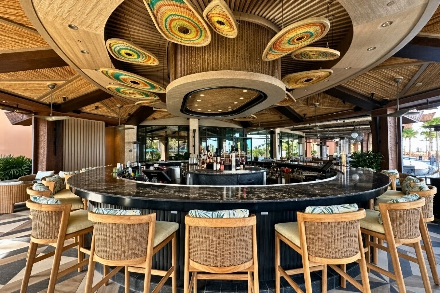 A bar area with a curved counter, wicker chairs, and a ceiling with circular light fixtures.