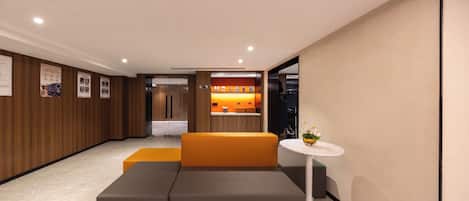 Un interior moderno con un sofá, una mesita y una zona de cocina.