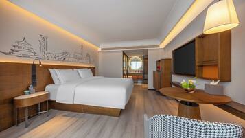 Une chambre d’hôtel avec un lit, une table de chevet, une lampe et un mur orné d’une fresque représentant un paysage urbain.