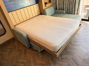 A compact bed with a mattress and a pull-out storage drawer. - Orlando | Couples Island Retreat | Pool + Beach (Golden Oak)