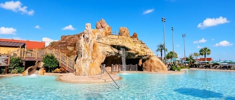 Una piscina con una formación rocosa y un puente.
