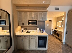 A modern kitchen with built-in appliances, wooden cabinetry, and a herringbone-patterned floor. - Orlando | Couples Island Retreat | Pool + Beach (Golden Oak)