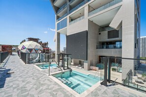 A modern building with a pool area, including a glass-enclosed pool and lounge seating. - 44th-Floor Condo w/ Stunning Miami Sunset View (Miami)