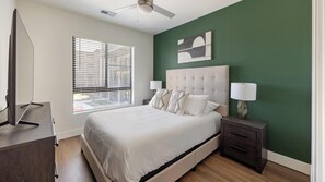 A bedroom with a bed, bedside tables, a ceiling fan, and a window with blinds. - Landing | Stylish 2BD, Clubhouse, Game Room (Goodyear)
