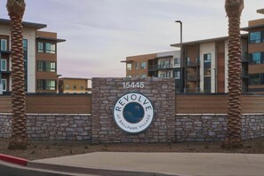 A modern building with a stone wall and a sign that reads 'REVOLVE AT BALLPARK VILLAGE.' - Landing | Modern 2BD, Game Room, Gym (Goodyear)