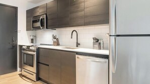 Una cocina moderna con electrodomésticos de acero inoxidable, lavavajillas y microondas.