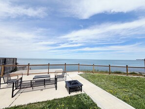 Eine Terrasse mit Sitzgelegenheit, Blick auf den Ozean und einem Holzzaun.
