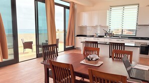 A modern kitchen with white cabinets, a black countertop, and a window with blinds. - Joli Penthouse 60m² Rooftop Terrace, 360° View (Sal)