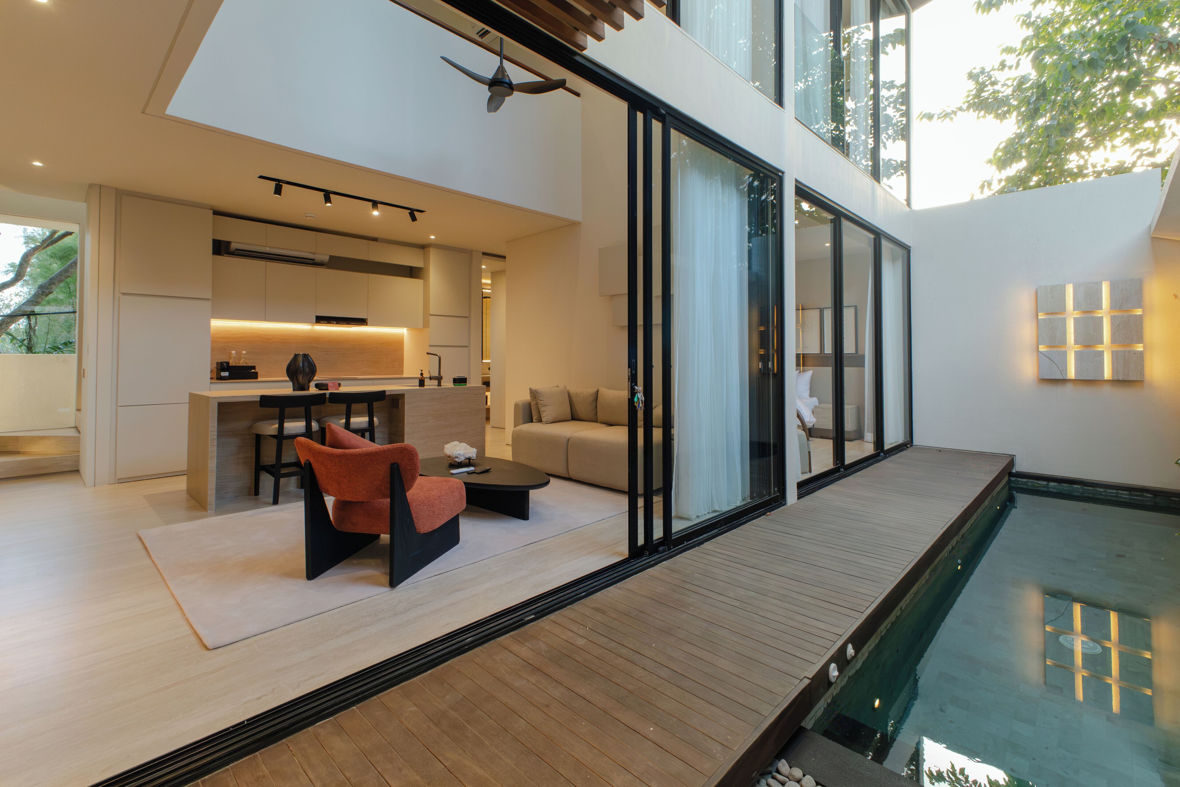 Un interior moderno con comedor, sofá y vista a la piscina.