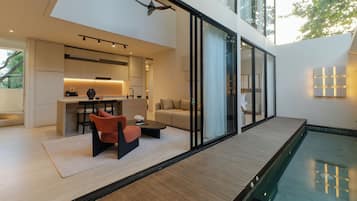 Un interior moderno con comedor, sofá y vista a la piscina.