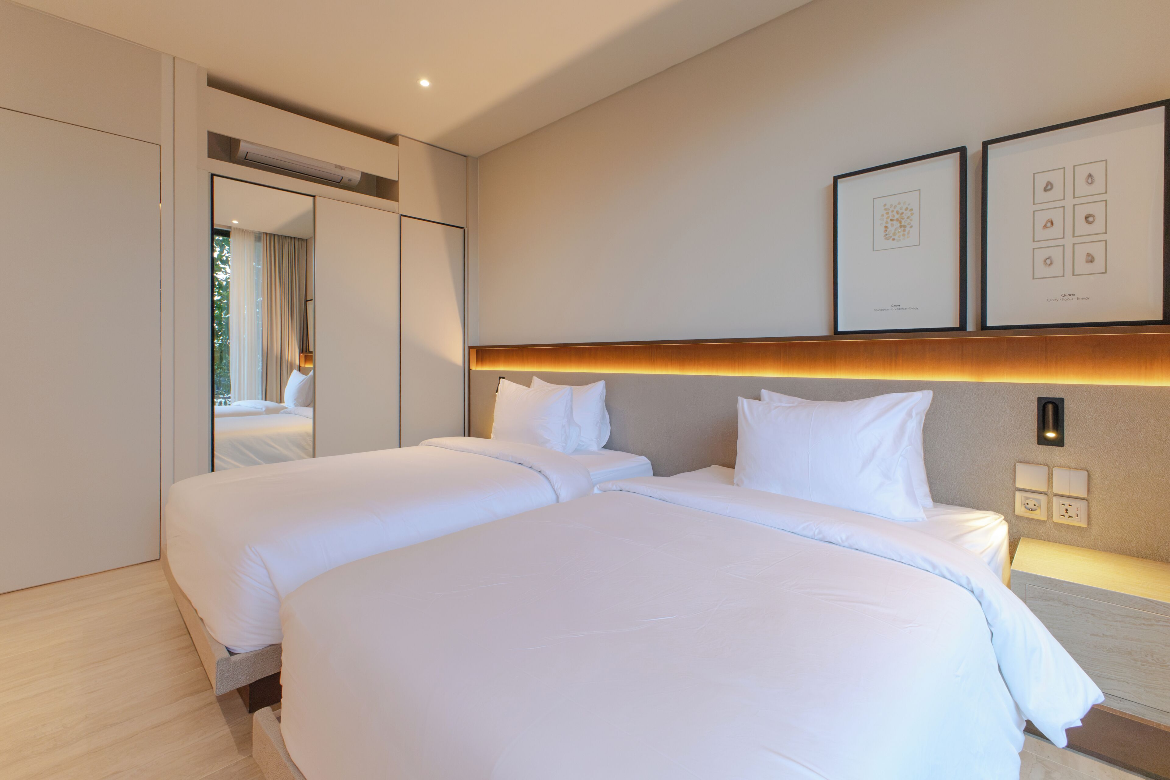 A hotel room with a large bed, a wardrobe, a mirror, and framed pictures on the wall.