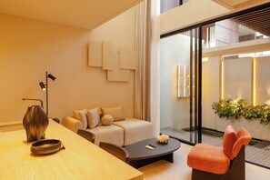 Una sala moderna con sofá, mesa de centro y comedor con mesa y sillas.