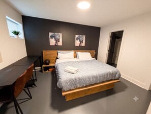 Ein Schlafzimmer mit einem Bett, einem Schreibtisch und zwei Wandbildern.