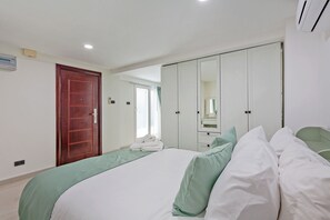 Ein Hotelzimmer mit Bett, Schrank, Badezimmer und Tür.