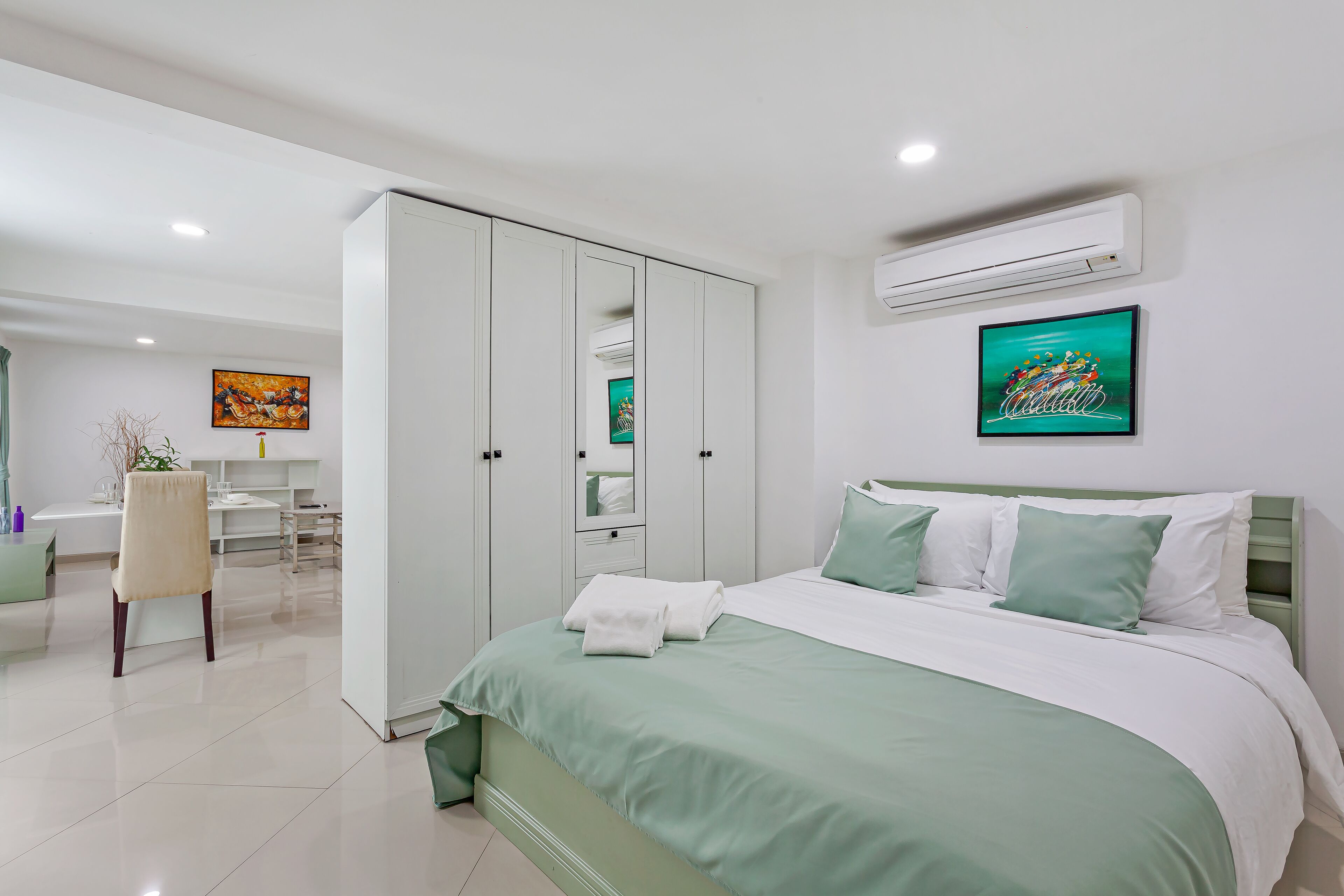 A modern bedroom with a bed, a wardrobe, a desk, and a chair.