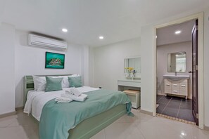 Ein Hotelzimmer mit einem Bett, einem Nachttisch, einem Spiegel und einem Badezimmer inklusive Waschbecken und Spiegel.