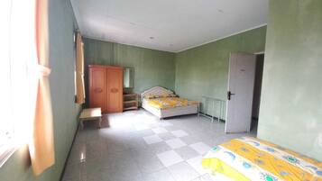 A bedroom with a bed, a wardrobe, a bench, and a door.