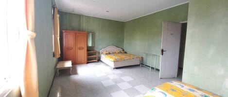 A bedroom with a bed, a wardrobe, a bench, and a door.