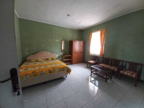 Ein Zimmer mit einem Bett, einem Holzschrank, einem kleinen Tisch und einer Couch.