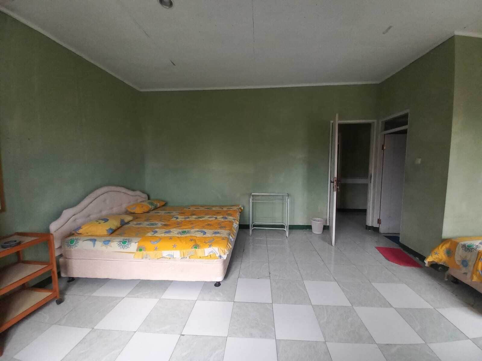 Um quarto com uma cama, uma mesinha e um guarda-roupa.